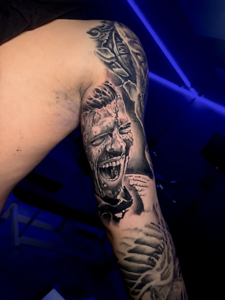 Tatuaje realista de un rostro gritando en el brazo