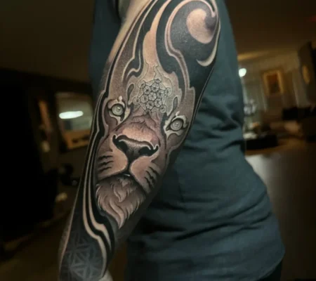 Tatuaje de león con ornamentos geométricos · Abian Manga con un león rodeado de ornamentos geométricos