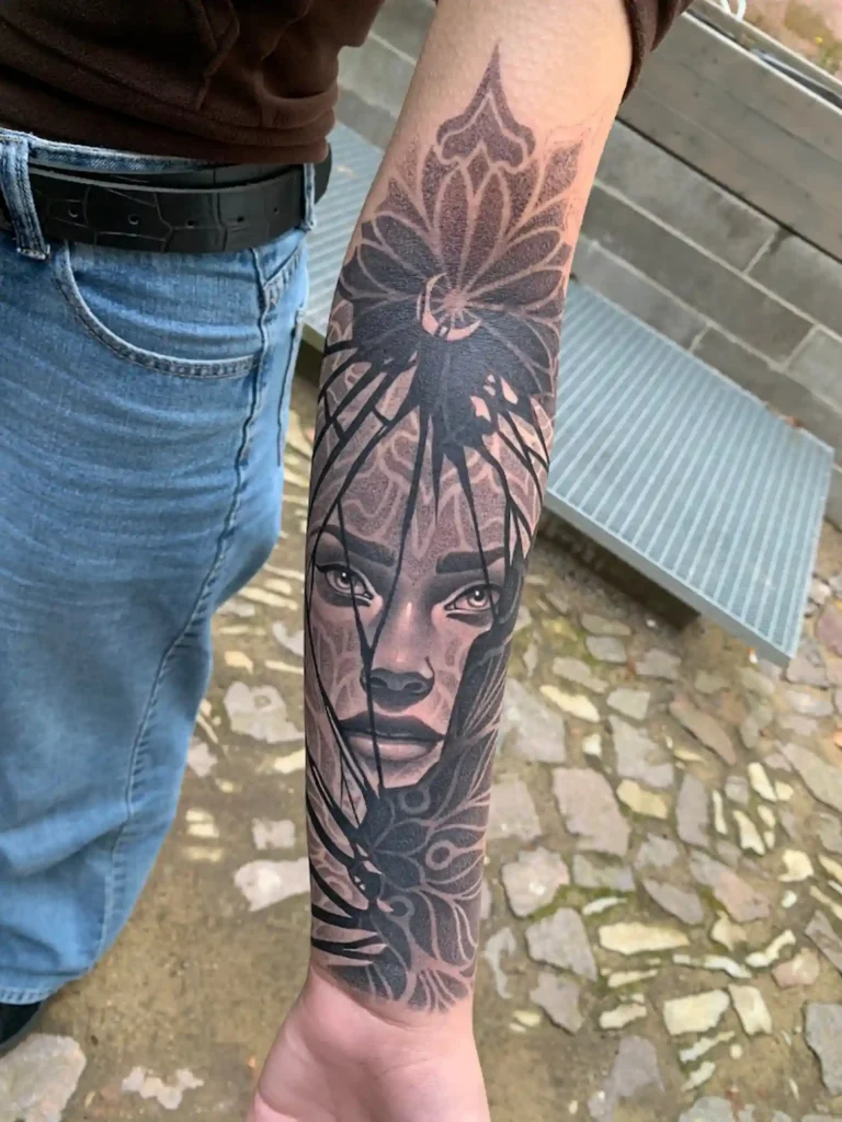 Rostro femenino realista con una flor de loto geométrica en el antebrazo