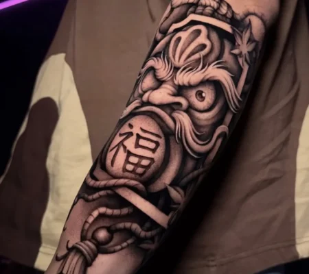 Tatuaje blackwork de máscara japonesa · Ashley Máscara japonesa con kanji en blackwork en el antebrazo