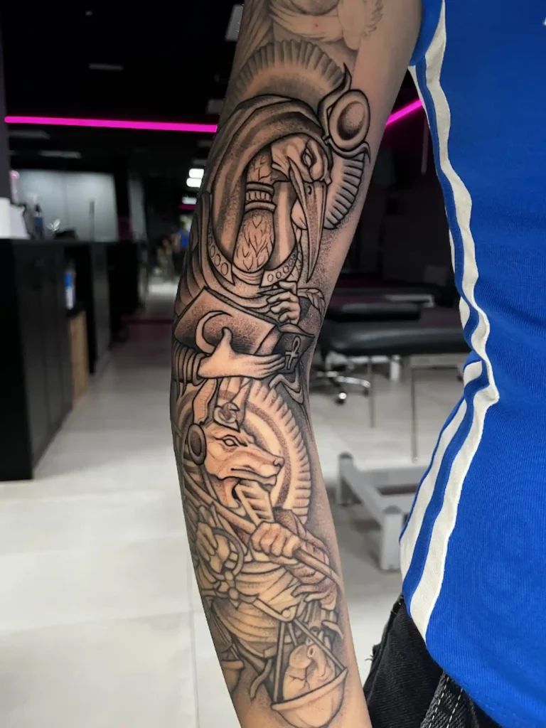 Manga en microrealismo con figuras egipcias en el antebrazo