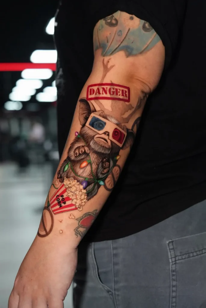 Mono con gafas 3D, palomitas y cartel de Danger a color en el antebrazo