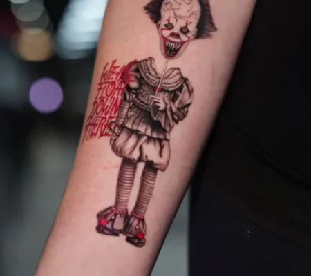 Tatuaje de Pennywise con detalles en rojo · Samantha Pennywise en el antebrazo con detalles y letras en rojo
