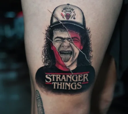 Tatuaje a color de Stranger Things · Samantha Personaje de Stranger Things a color con el logo de la serie en el muslo