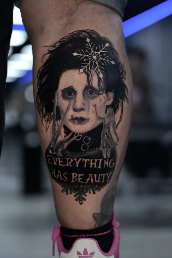 Eduardo Manostijeras con copo de nieve y la frase Everything has beauty en el gemelo