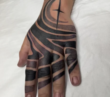 Tatuaje blackout en mano y dedos · Gabri Mano y dedos cubiertos de blackout con líneas en negativo