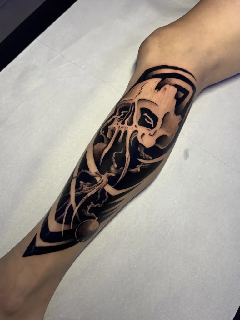 Antebrazo de blackout con una calavera dibujada en negativo