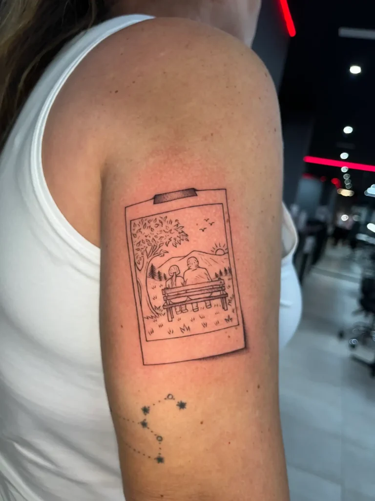 Polaroid con un paisaje tatuada en fine line en el brazo