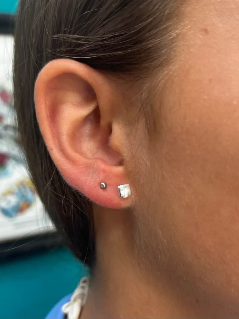 Lóbulo de la oreja con dos piercings de brillante
