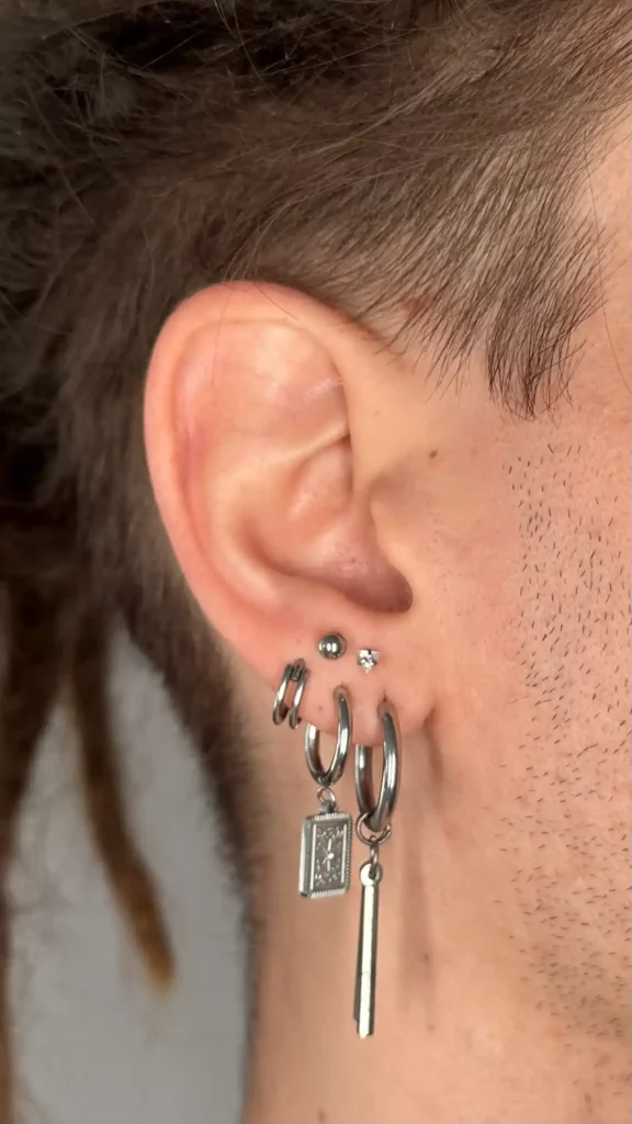 Oreja con varios aros y colgantes en el lóbulo