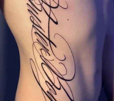 Tatuaje de lettering ornamental en el costado · Isabella Lettering ornamental de gran tamaño en el costado