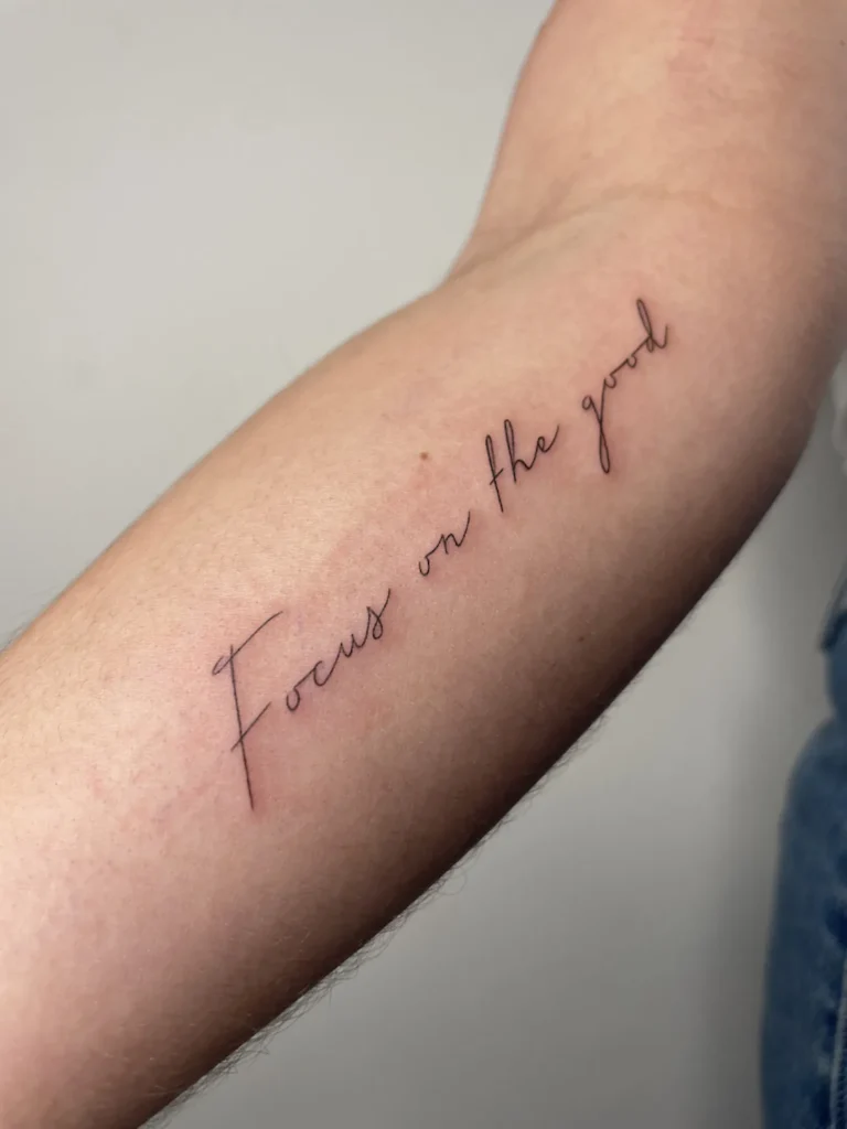 Lettering en fine line con la frase Focus on the goal en el antebrazo