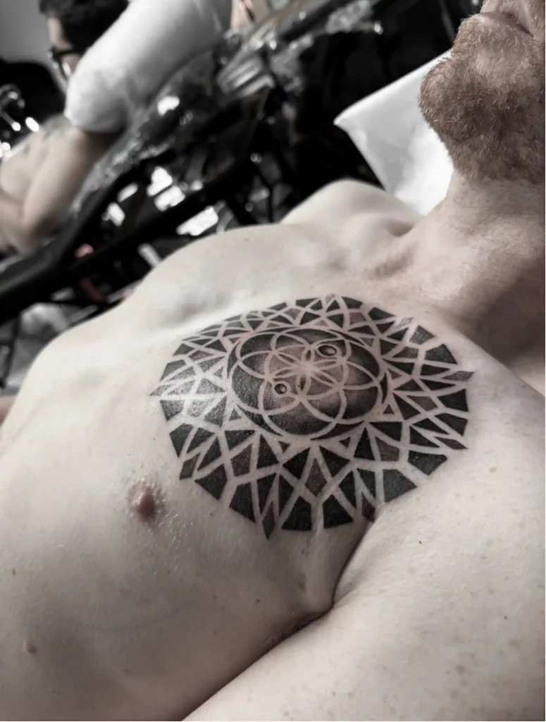 Mandala de geometría sagrada tatuado en el pecho